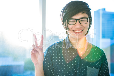 Smiling hipster businessman doing peace sign