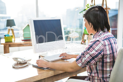 Hipster businessman using computer while writing