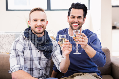 Gay couple toasting on the couch