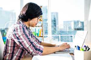 Serious hipster businessman using laptop