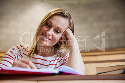 Female student taking notes in a class