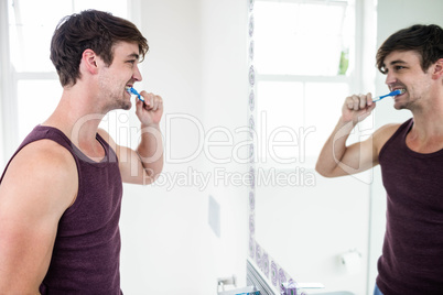Handsome man cleaning his teeth