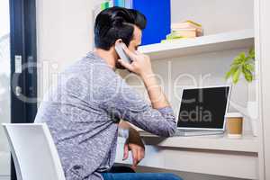 Busy man using smartphone and laptop