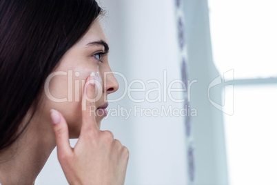 Brunette applying face cream