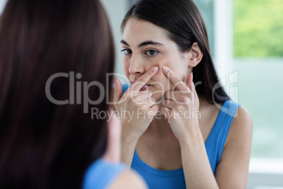 Unhappy woman with skin irritation cleaning her face