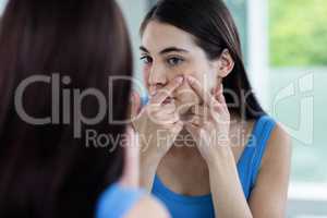 Unhappy woman with skin irritation cleaning her face