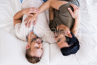 Happy gay couple lying on bed