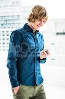 Smiling hipster businessman texting