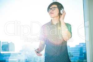 Smiling asian businessman listening to music