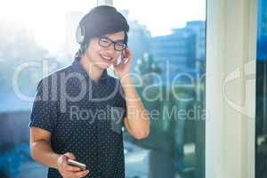 Smiling asian businessman listening to music