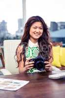 Creative businesswoman holding camera