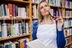 Thoughtful female student holding a book