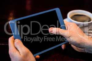 Businessman using tablet having a coffee