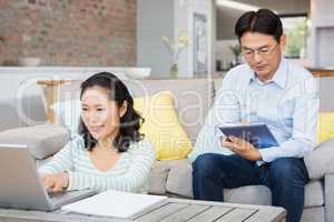 Smiling couple using laptop and tablet