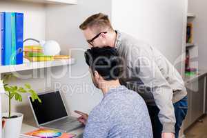 Serious gay couple using laptop