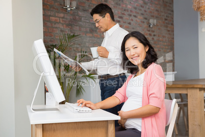 Smiling pregnant woman using laptop