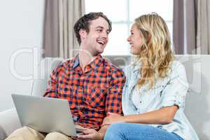 Couple using laptop on the couch