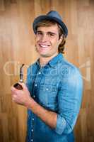 Cheerful hipster holding pipe