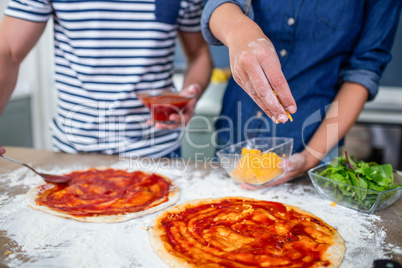 Smiling couple preparing pizza