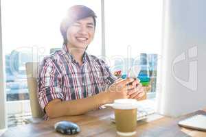 Smiling hipster businessman using smartphone