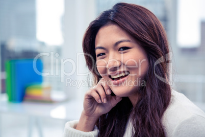 Smiling Asian woman with hand on cheek