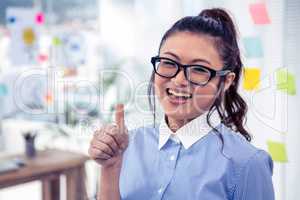 Smiling Asian businesswoman showing thumb up