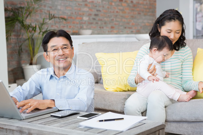 Smiling man counting bills in the living room