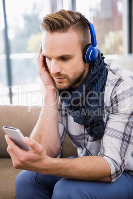 Handsome man listening music on the couch