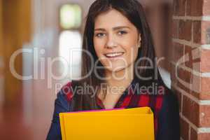 Smiling student with binder posing