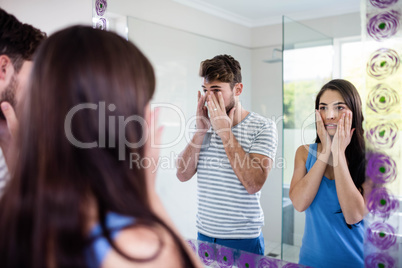 Couple looking themselves in the mirror