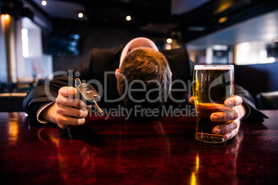 Drunk man holding a beer and car keys