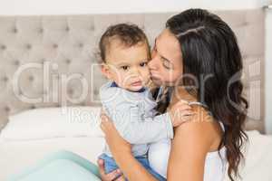 Smiling brunette kissing her baby