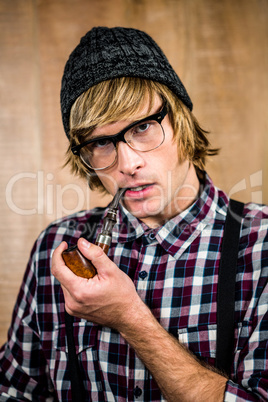 Serious blond hipster smoking a pipe