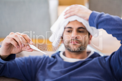 Sick man checking his temperature