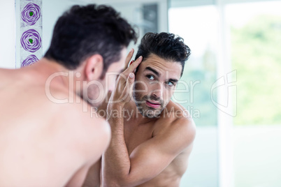 Handsome man looking at his hair