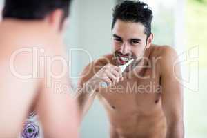 Portrait of a handsome man brushing teeth