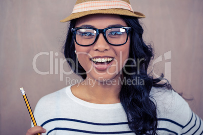 Attractive Asian woman with hat holding pencil