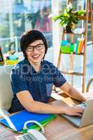 Smiling hipster businessman using laptop
