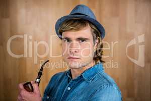 Serious hipster holding pipe