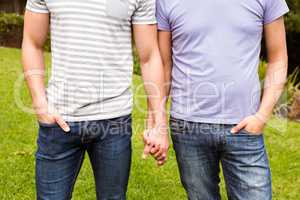 Mid section of gay couple with hand in hand