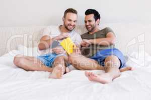 Happy gay couple reading book
