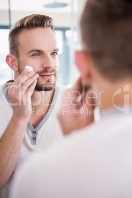 Smiling man shaving his beard