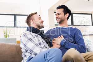 Gay couple looking at each other on the couch