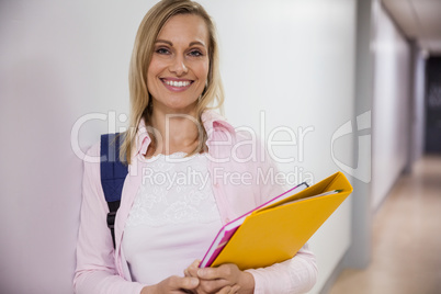 Happy female student walking in the hallway