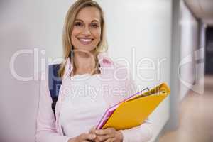 Happy female student walking in the hallway