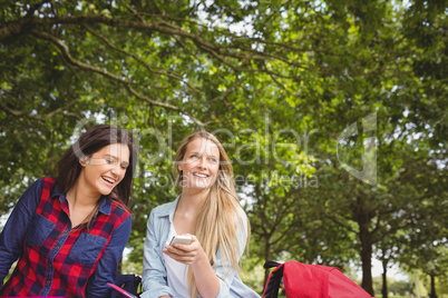 Smiling students using smartphone