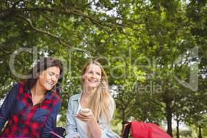 Smiling students using smartphone