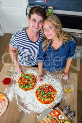 Smiling couple preparing pizza