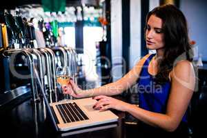 Woman using laptop and having a drink