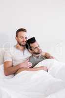 Asleep gay couple lying in bed